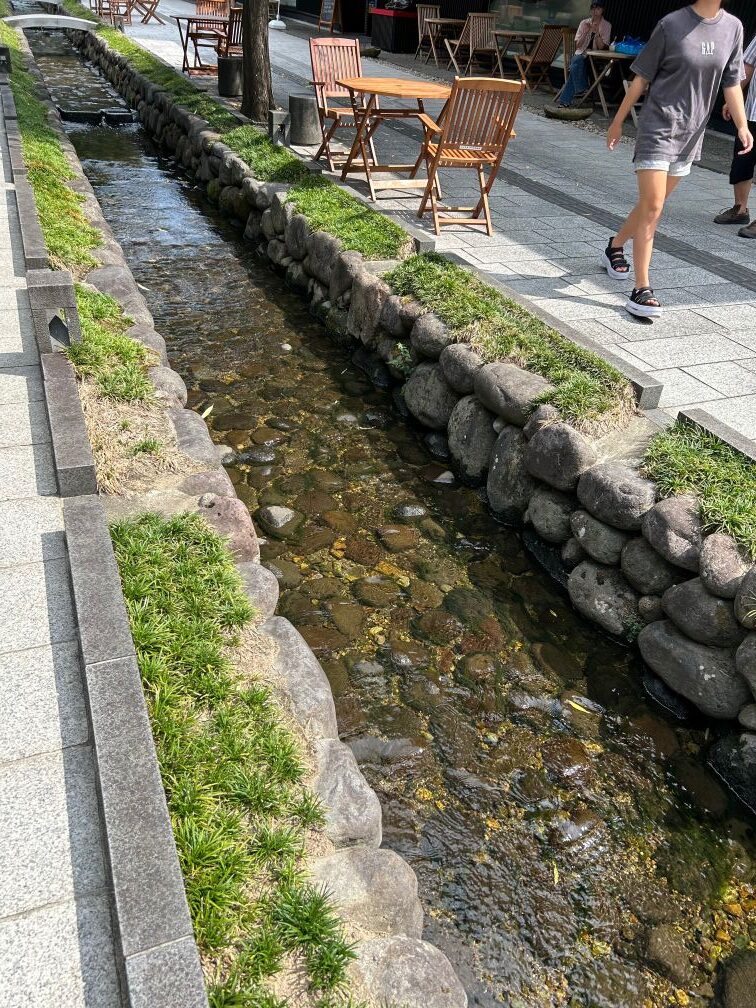 山形市七日町の御殿堰を流れる石積みの水路とベンチの風景